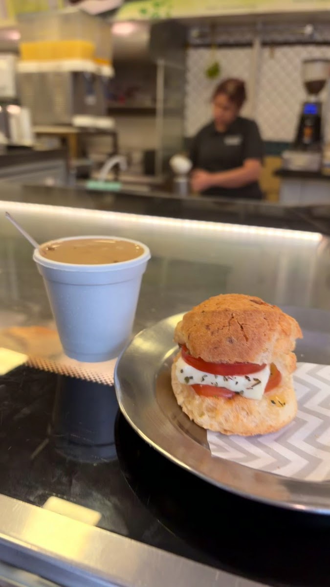 Café pingado e sanduíche de queijo com tomate no balcão