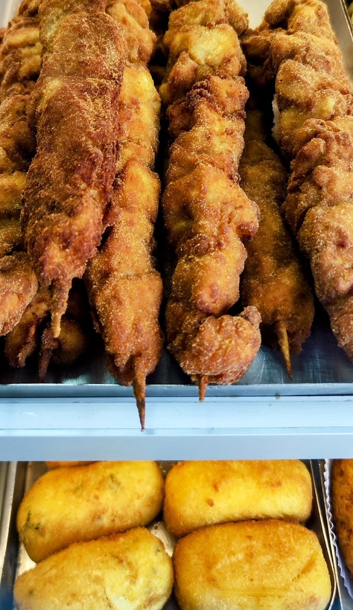 Espetinhos empanados e coxinhas na vitrine da lanchonete